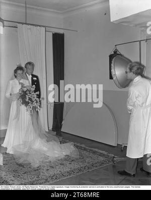 Kissing in the 1940s. Newlyweds couple Rohlsson having their wedding picture taken by a professional photographer in a studio.     Sweden 1941 Kristoffersson Ref 199-1 Stock Photo