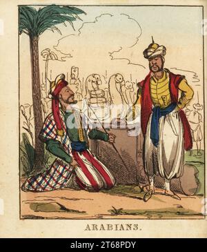 Two Arabian men under a palm tree in front of a caravan of camels. In turban, colourful robes, harem pants and slippers, one smoking a tobacco pipe. Handcoloured copperplate engraving from The World in Miniature, or Panorama of the Costumes, Manners & Customs of All Nations, John Bysh, London, 1825. Stock Photo