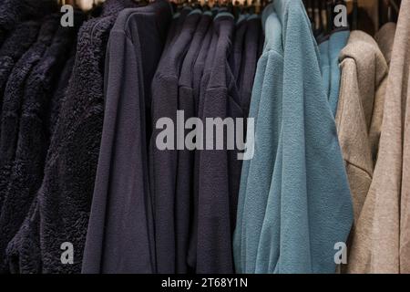 men's sportswear hanging on hangers in a store Stock Photo