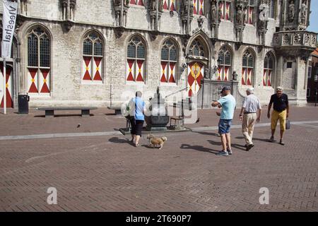 A model of Middelburg on a plinth with the Gothic town hall and two chairs and tourists on the Markt in front of the town hall. Netherlands, June Stock Photo