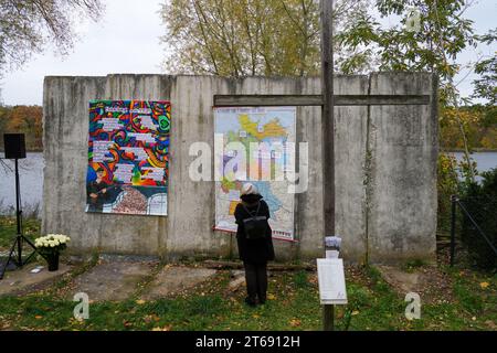 Potsdam, Germany. 09th Nov, 2023. A woman looks at an overview map attached to a piece of the Wall with the inscription 'Mood map for November 9 and after' during a commemorative event on the banks of Lake Griebnitzsee in Brandenburg to mark the 34th anniversary of the fall of the Wall. Credit: Soeren Stache/dpa/Alamy Live News Stock Photo
