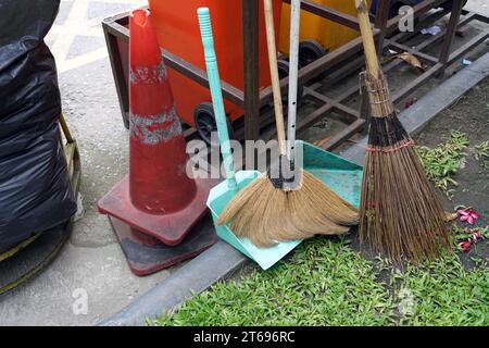 Broom and cleaning equipment with plastic trash can on the street on the cement floor of the carpark Stock Photo
