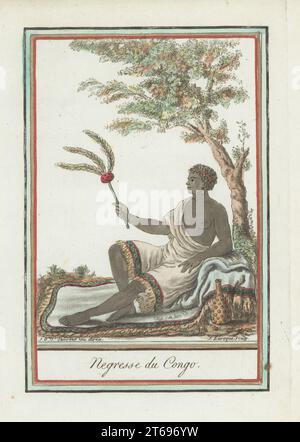 A woman of the Kingdom of Congo, Africa. She wears a headband, earrings, a fringed gown, sits on a carpet under a tree with fan and flagon. The kingdom of Kongo covered parts of modern Angola, Gabon and Congo. Negresse du Congo. Handcoloured copperplate engraving by J. Laroque after a design by Jacques Grasset de Saint-Sauveur from his Encyclopedie des voyages, Encyclopedia of Voyages, Bordeaux, France, 1792. Stock Photo