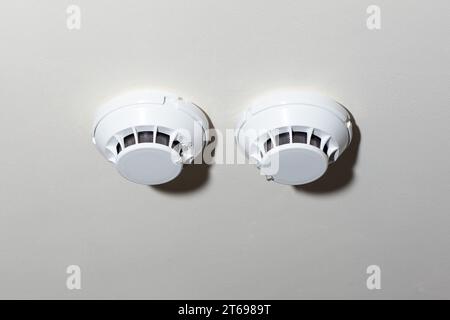 White ceiling-mounted smoke detectors for fire safety and protection. Essential security equipment Stock Photo