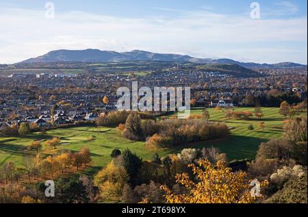 Holyrood Park views, Edinburgh, Scotland, UK. 9 November 2023. After a frosty start to the day the sun appeared by 9am and highlighted the remaining autumnal foliage of the deciduous trees which surround the south side of the historic park, temperature eventually increasing to 8 degrees centigrade. Pictured Prestonfield Golf Course in foreground with Blackford and Pentlands Hills in the background. Credit: Archwhite/alamy live news. Stock Photo