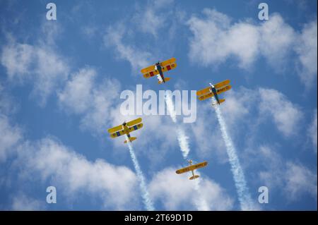 Four airplanes flying in formation, leaving trails of smoke behind them as they soar through the sky Stock Photo
