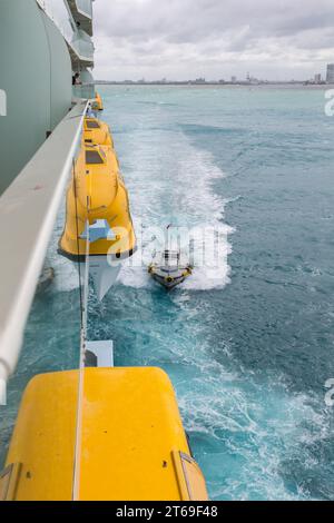 Pilot boat positioning to receive harbor pilot from the Royal Caribbean Allure of the Seas cruise ship in the Atlantic Ocean off Fort Lauderdale, FL Stock Photo
