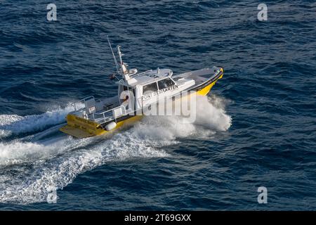 Pilot boat in the Caibbean Sea being positioned to bring the harbor pilot onto a cruise ship off the coast of Phillipsburg, St. Martin Stock Photo