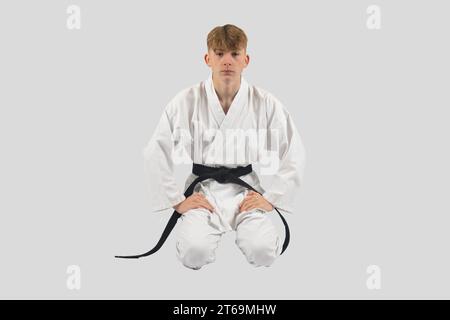 Black belt teenage boy in Seiza, kneeling down Stock Photo
