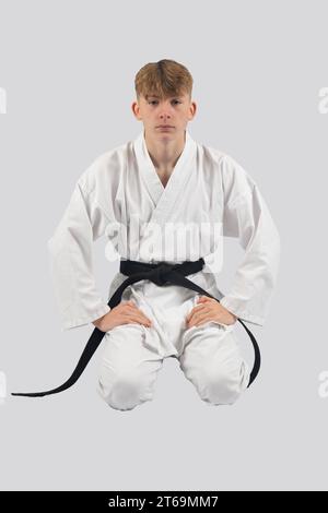 Black belt teenage boy in Seiza, kneeling down Stock Photo