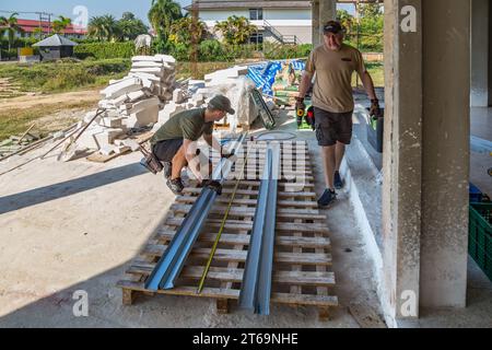 American men preparing metal studs while volunteering to help build the Grace Language School and Baan Athitaan Church in Chiang Rai, Thailand Stock Photo