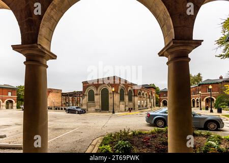 View through the arch of a columned apartment on Market Square to the remaining buildings of Market Hall, built in 1893. Each building contains three apartments, one on the second floor and two on the upper floor. The Pullman Company used these apartments during the Columbian Exposition of 1893 to accommodate guests attending the fair in nearby Hyde Park. Chicago's Pullman neighborhood has been gentrifying since the end of the 20th century. Many residents are involved in the restoration of their own homes and in projects throughout the neighborhood. Chicago, Illinois, United States Stock Photo