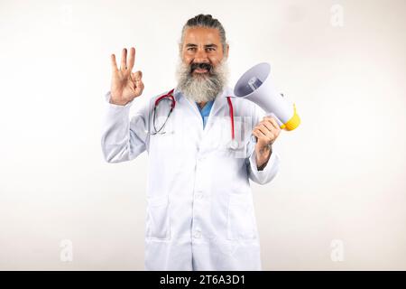 A mature male wearing a white laboratory coat proudly displays arias while facing the camera Stock Photo