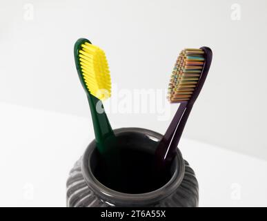 Toothbrushes in ceramic bowl on blurred background. Colorful toothbrushes, healthy tooth concept. Stock Photo