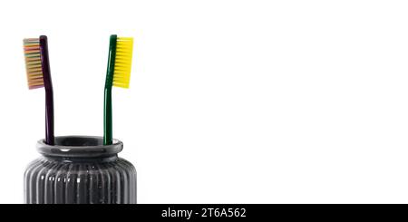 Toothbrushes in ceramic bowl isolated on white. Colorful toothbrushes, healthy tooth concept. Stock Photo