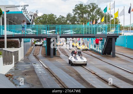 Black man and son riding a car in the Tomorrowland Speedway at the Tomorroland area of the Magic Kingdom at Walt Disney World, Orlando, Florida Stock Photo