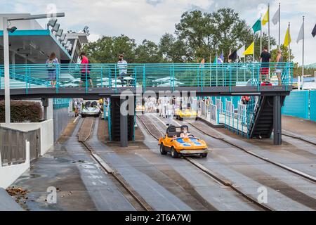 Woman and son riding a car in the Tomorrowland Speedway at the Tomorroland area of the Magic Kingdom at Walt Disney World, Orlando, Florida Stock Photo