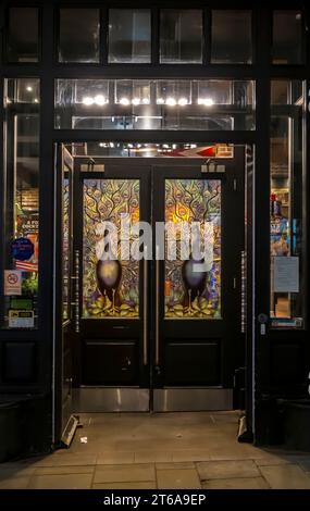 Close up of entrance doors to FRIDAYS bar and restaurant at night, High Street, Lincoln City, Lincolnshire, England, UK Stock Photo