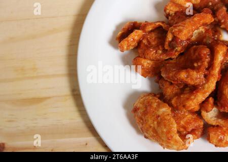 Fried Pork Skins With Red Salsa in Plate on Table Stock Photo