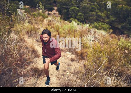 Run with your heart if your legs get tired. a young man out for a trail run. Stock Photo