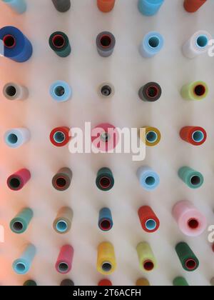 Abstract image of lines of coloured circles formed from a display of spools of sewing threads in a display on the ceiling at Paisley Thread Museum. Stock Photo