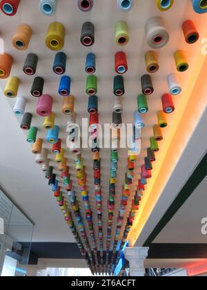 A display in lines of spools of coloured threads on the ceiling at Paisley Thread Mill Museum, which celebrates the industrial heritage of the area. Stock Photo