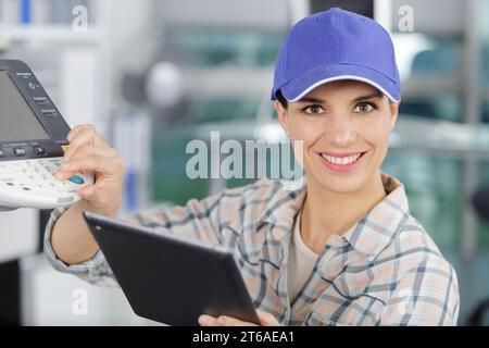 happy woman smiling at the camera fixing a printer Stock Photo