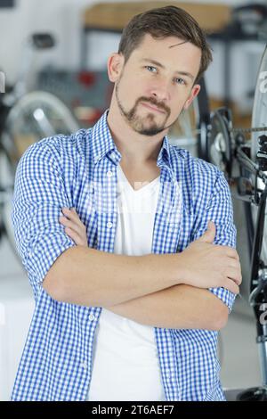 friendly and competent bicycle mechanic in a workshop posing Stock Photo