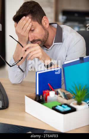 sad businessman in light modern office with carton box Stock Photo