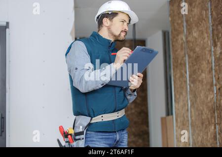 male builder writting on clipboard Stock Photo
