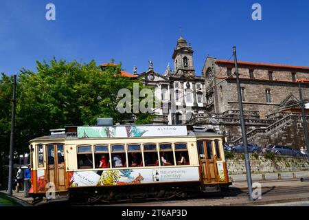 Old fashioned tram at Infante station, San Francisco church in background, Ribeira district, Porto / Oporto, Portugal Stock Photo