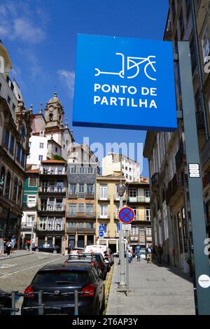 Electric scooter sharing point sign on Rua de Ferreira Borges, Igreja da Vitória church tower in background, Ribeira, Porto / Oporto, Portugal Stock Photo