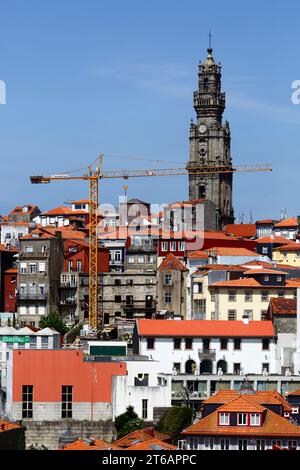 Yellow tower crane, old houses in Ribeira district and Torre dos Clérigos church tower, Porto / Oporto, Portugal Stock Photo