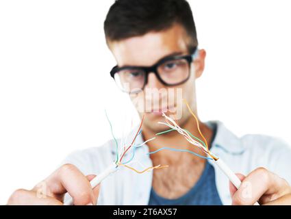 Electrician, working and man with cables, test and and check for power in white background. Studio, technician or electricity, wires and maintenance Stock Photo