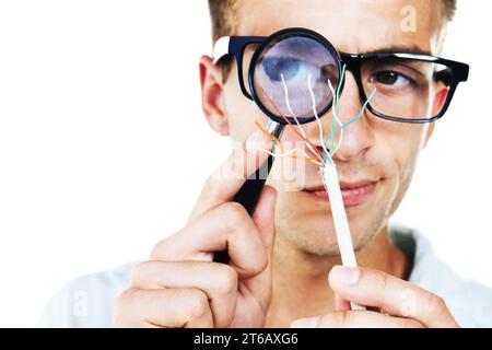 Magnifying glass, technician and hand of man with cables or problem solving in white background. Studio, electrician or working with electricity Stock Photo