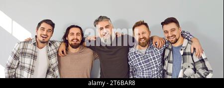 Group of happy five male friends in casual wear standing and laughing Stock Photo