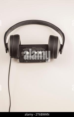 Sennheiser HD 300 stereo headphones with audio tape cassette on white background. Stock Photo