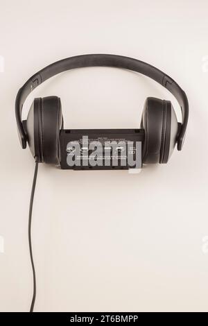 Sennheiser HD 300 stereo headphones with audio tape cassette on white background. Stock Photo