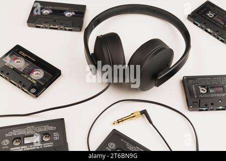 Sennheiser HD 300 stereo headphones with gold plated phone jack and audio tape cassettes on white background. Stock Photo