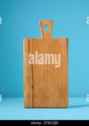 empty wooden cutting board on blue background Stock Photo