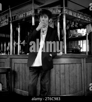 Legendary Irish rockstar, singer/songwriter & frontman for The Pogues & The Popes, Shane MacGowan pictured drinking and smoking at his favourite London pub Filthy MacNasty’s , Islington 1994 Stock Photo