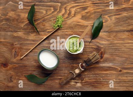 Composition with powdered matcha tea, milk and accessories on wooden background Stock Photo