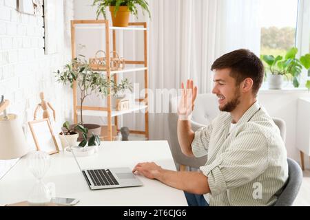 Young bearded man video chatting at home office Stock Photo