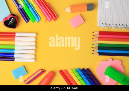 Frame made of different school stationery on yellow background, flat lay and space for text. Back to school Stock Photo