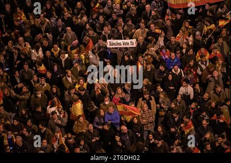 A demonstrator holds a placard reading 'Sanchez, go away now' during a protest in front of socialist party PSOE headquarters in Ferraz street for the seventh consecutive day of protests following the recent agreement between PSOE and Junts party, which unfolded today in Brussels. Thousands have gathered called by far right wing groups to show their rejection against the approval of an amnesty for Catalan separatist leaders which is included in the agreement and guarantees the investiture of the socialist candidate Pedro Sanchez. Stock Photo