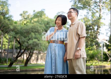 Happy retired senior Asian couples are strolling around a public park on the weekend together. Leisure, happy marriage, healthy relationship Stock Photo
