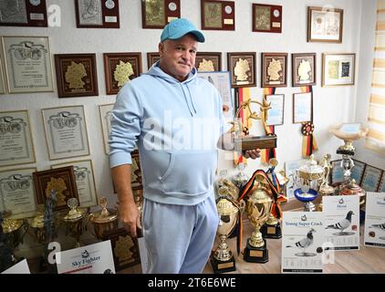 PRODUCTION - 30 October 2023, Baden-Württemberg, Königsbach-Stein: Pigeon fancier Andreas Drapa holds his first major trophy, which he won with his pigeons. He has already won numerous competitions with his pigeons and sells animals worldwide. The breeder from the Enzkreis region lives for his animals. (to dpa 'Racing pigeons from Baden in demand worldwide') Photo: Bernd Weißbrod/dpa Stock Photo