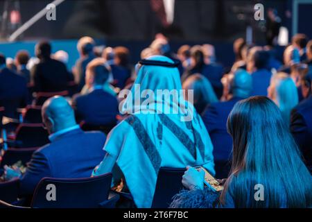 Back view of Arabian businessman attending global conference meeting in illuminated auditorium at export forum Stock Photo