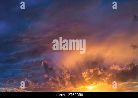 Glowing real sky at sunset texture background overlay. Dramatic red, orange, and purple clouds. High resolution photography perfect for sky replacemen Stock Photo