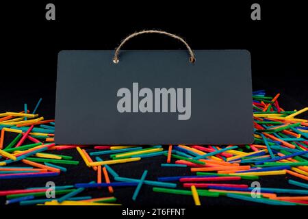 Rectangular shaped black notice board on colorful sticks on black Stock Photo